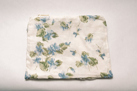 Cream floral zipper pouch with blue and green botanical print, top zipper closure
