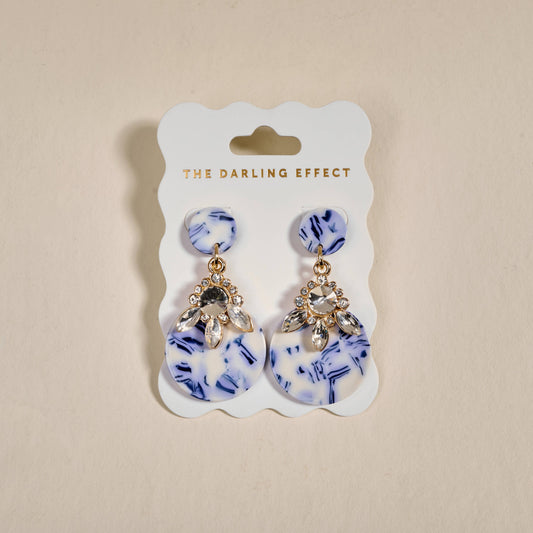 Earrings with blue-and-white drop shapes, crystal flower tops, and gold-tone leaves