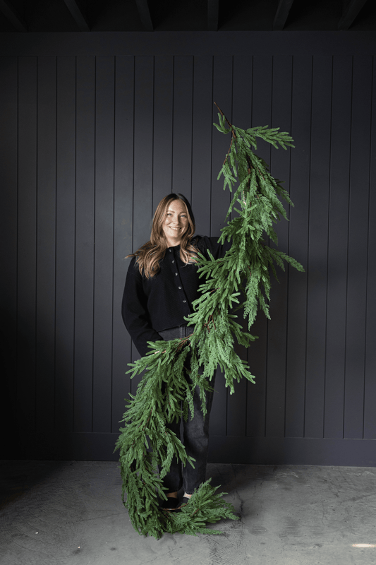 Artificial green Christmas garland featuring dense hanging foliage and full ends