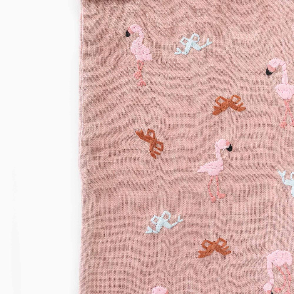 Beige stocking panel close-up with pink flamingo and small bow embroidery