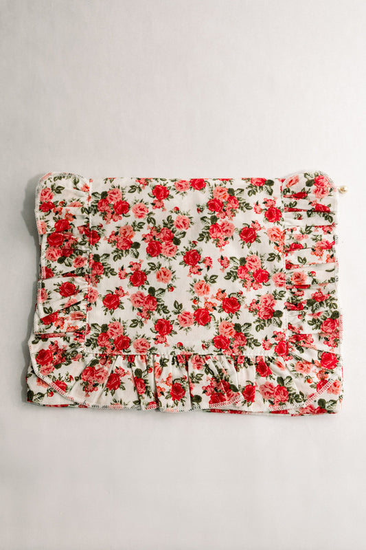 Floral ruffle pouch with red rose blossoms, gathered skirt hem, and gold zipper pull