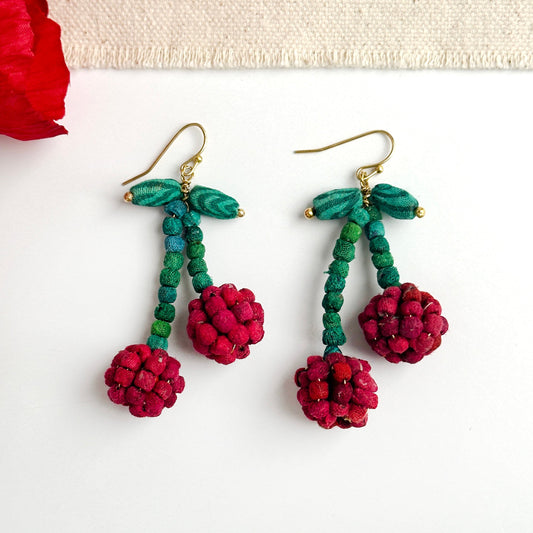 Pair of teal and red beaded drop earrings with gold hooks and berry pom-poms.