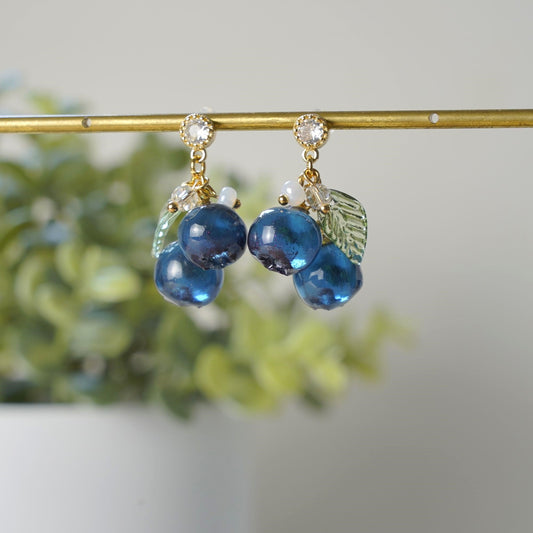 Blue resin berry drop earrings with green leaf charms and gold-tone top loops