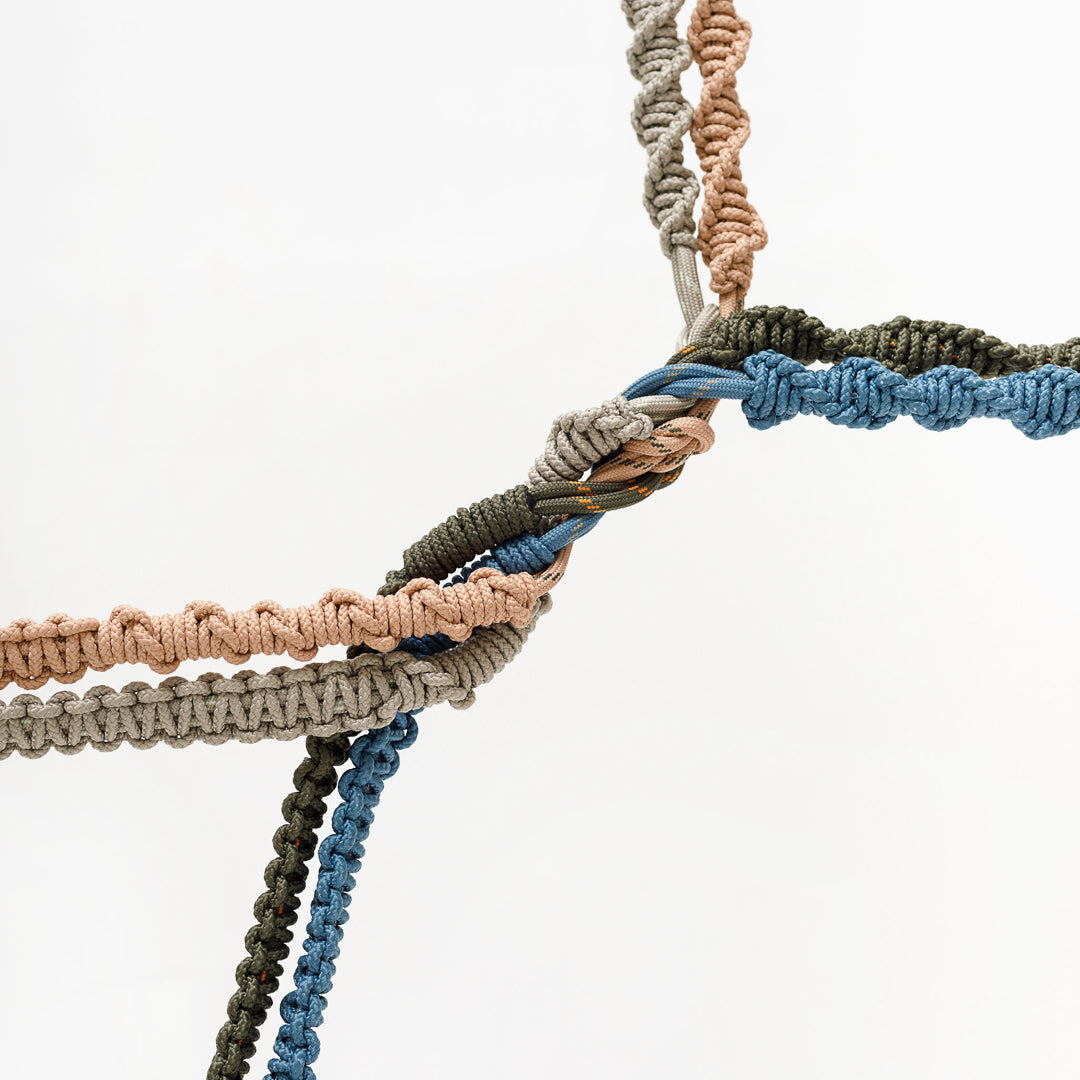 Macrame strap knot detail with braided cord and stormy blue trim; metal ring clip
