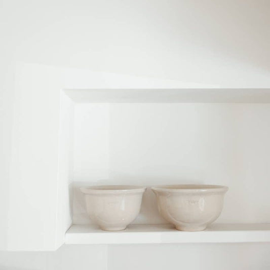 Two cream stoneware mixing bowls in small and large sizes