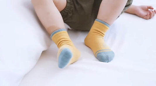 Kids organic cotton socks on toddler feet: mustard yellow with light blue stripes