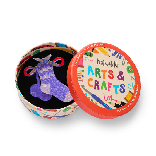 Decorative round tin with black sock graphic and colorful Arts & Crafts badge