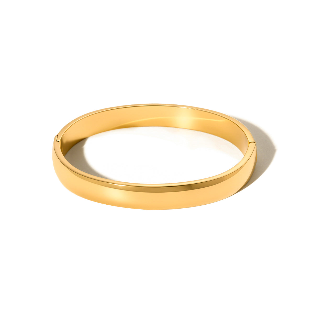 Gold-tone polished bangle bracelet, open round shape on white background