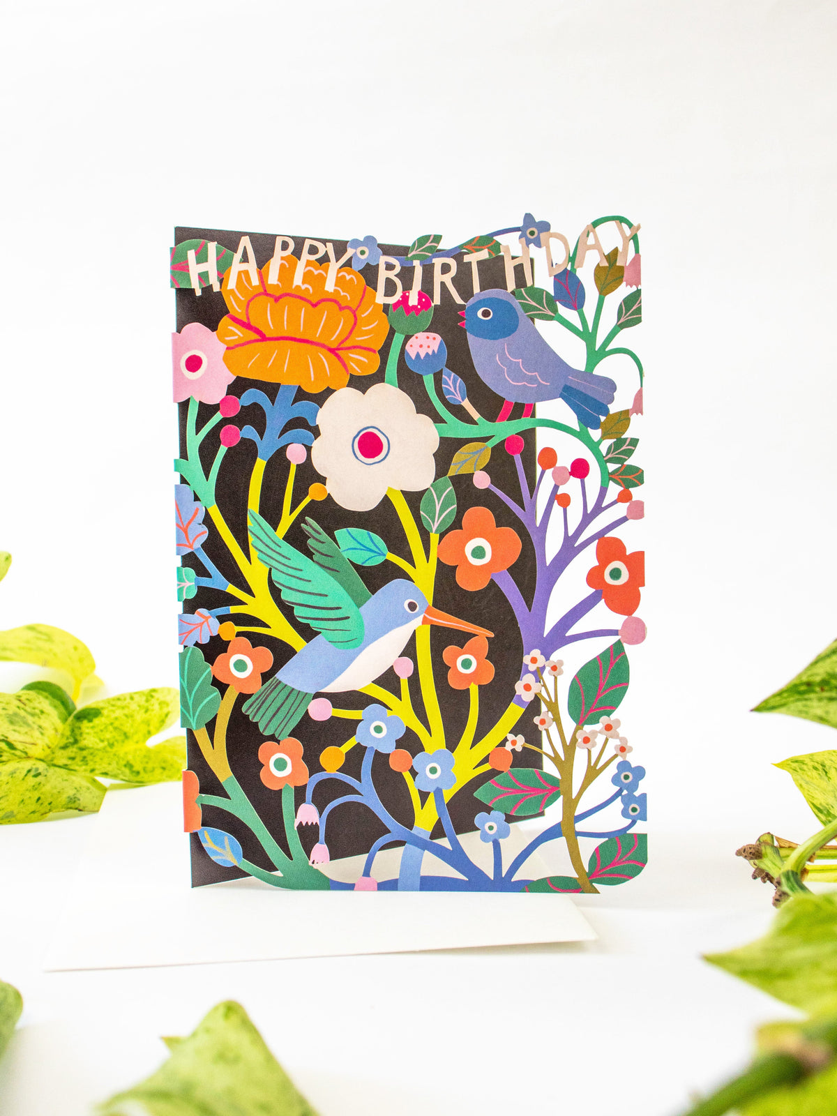 Laser-cut birthday card front with layered birds and blooms around “Happy Birthday”
