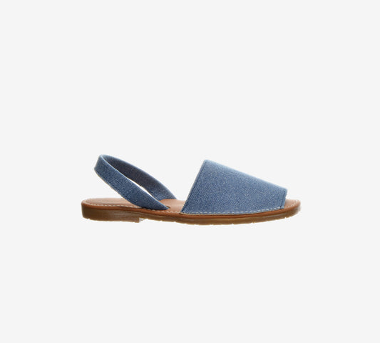 Side view of a blue denim Menorcan sandal with an open heel and brown flat sole.