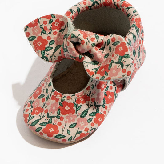 Floral baby shoe pair close-up with knotted bow and cushioned interior