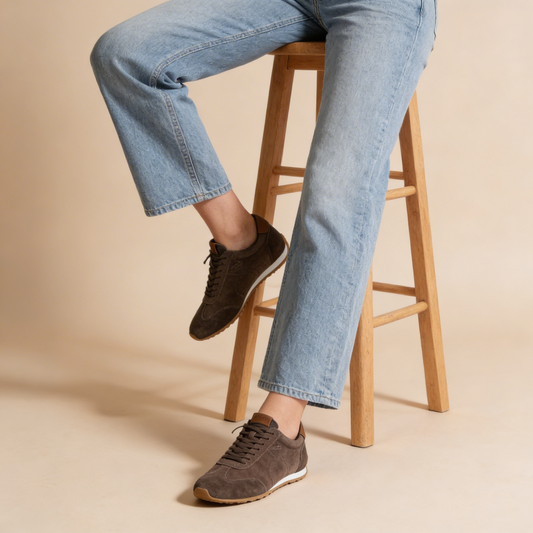 Bristol Chocolate suede sneakers shown worn with jeans, featuring brown laces and light soles