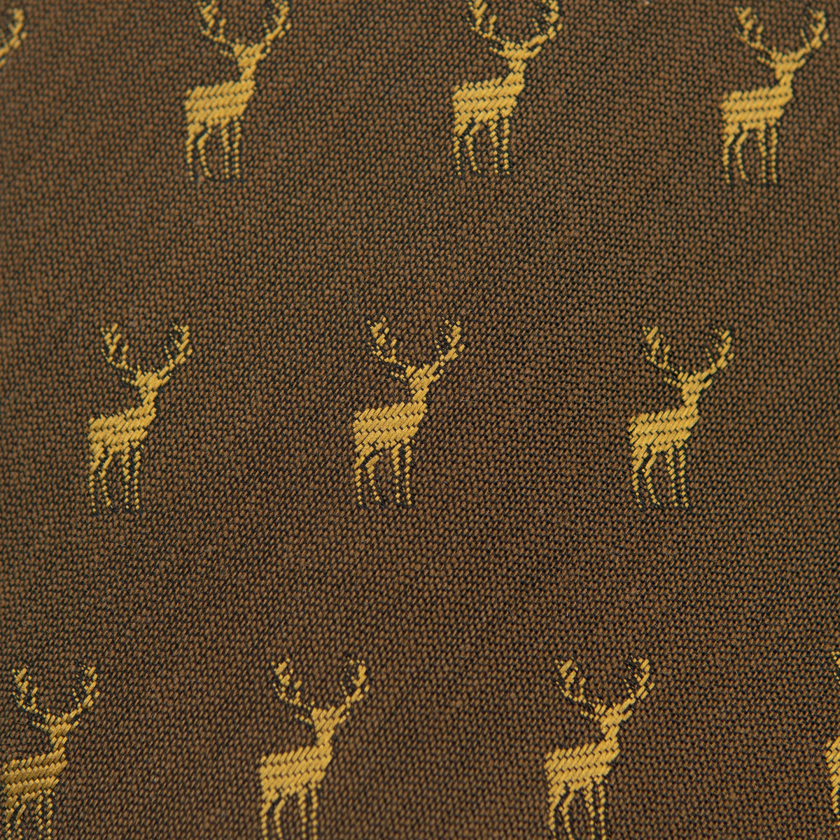 Fabric close-up with repeating yellow deer icons on dark brown