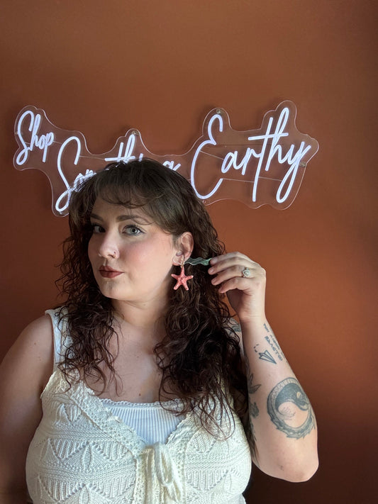 Starfish-shaped red hoop earrings on model