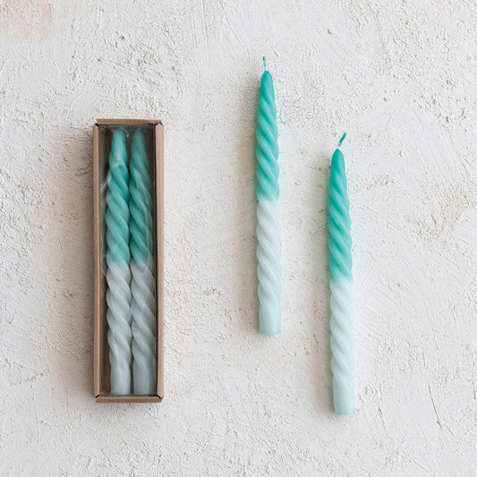 Ombre teal-to-white twisted taper candles, two upright on wall