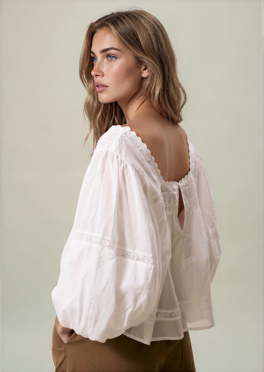 White puff sleeve blouse with lace trim at neckline and embroidered yoke detail
