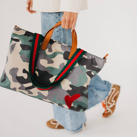 Camouflage-print canvas tote with tan handles, green trim, and red heart charm