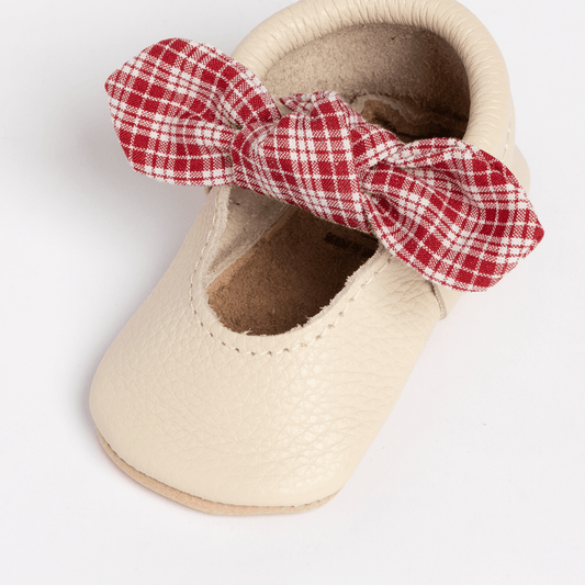 Single Prairie Girl baby shoe with red plaid knotted bow and cream leather