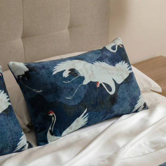 Blue small lumbar pillow with white cranes and subtle red beak embroidery pattern.