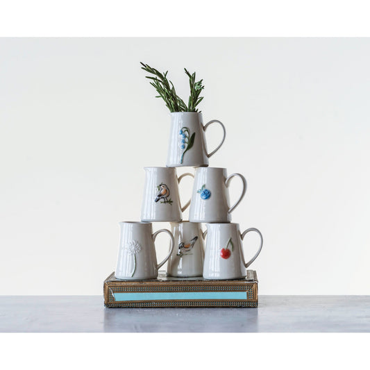 Mini ceramic creamer cups stacked on a decorative tray, blue flower and bird designs