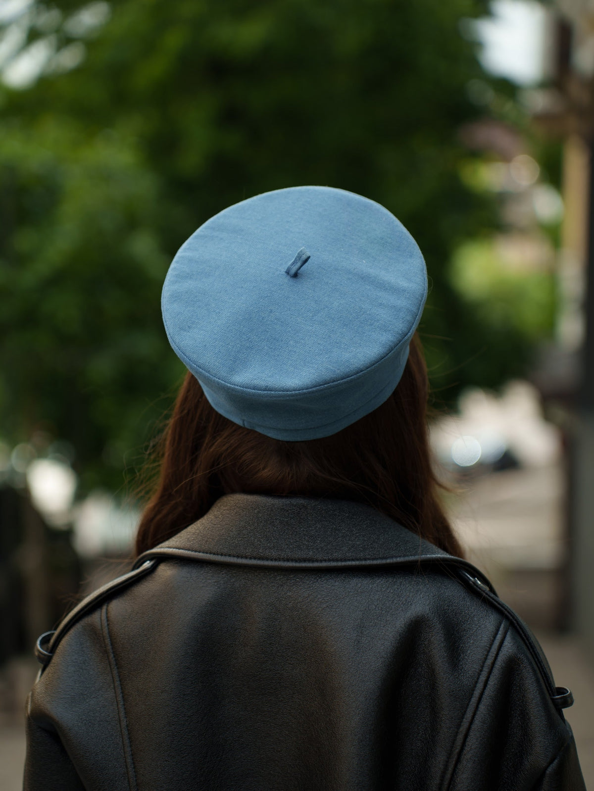 Back view of a blue Paris beret, showing the crown, folded band, and top tab
