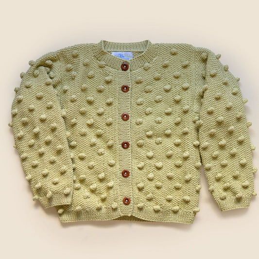 Light yellow knit cardigan with textured dot pattern and brown button placket