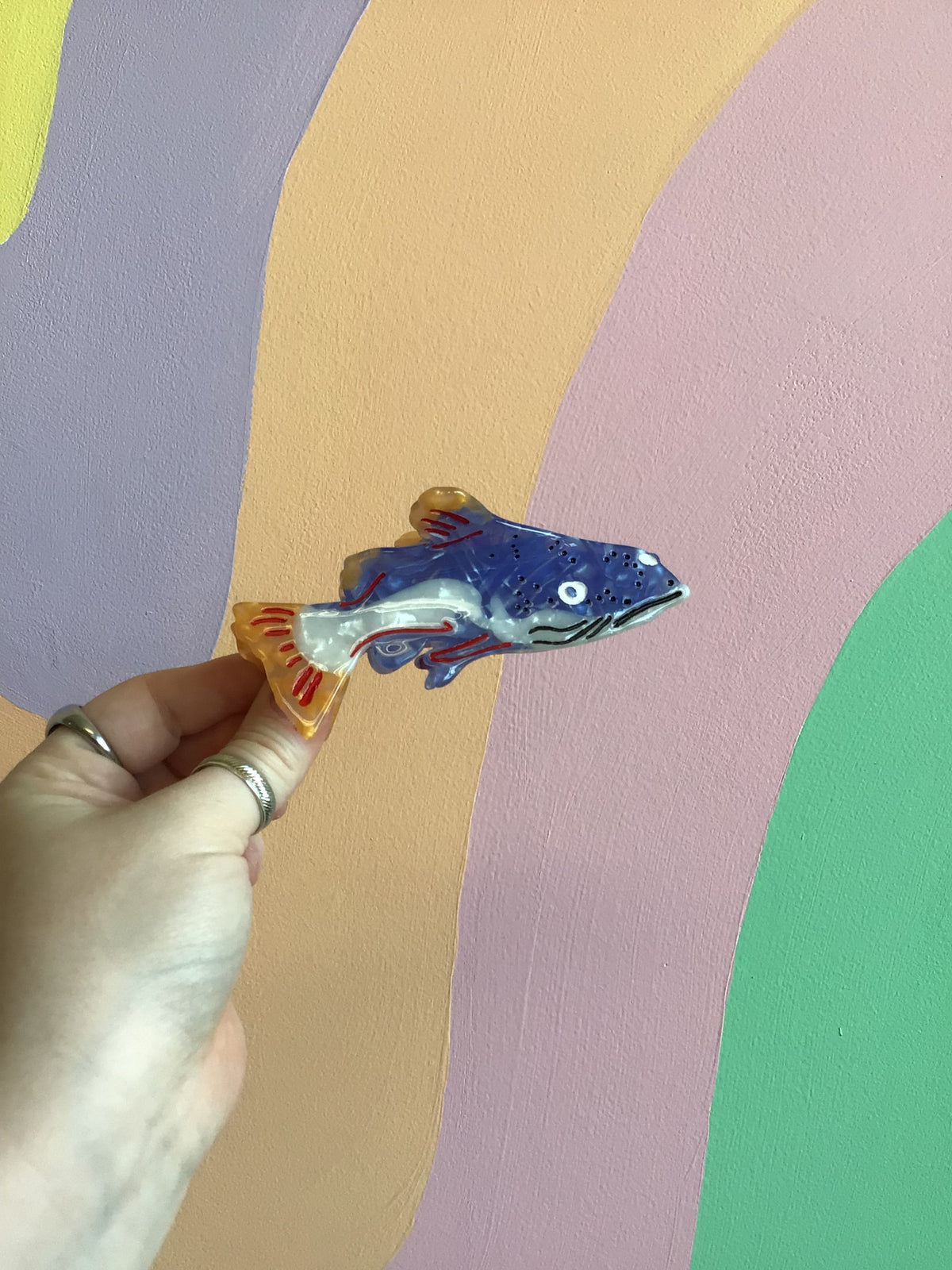 Fish-shaped hair claw clip with blue body, red accents, and shiny clear edges