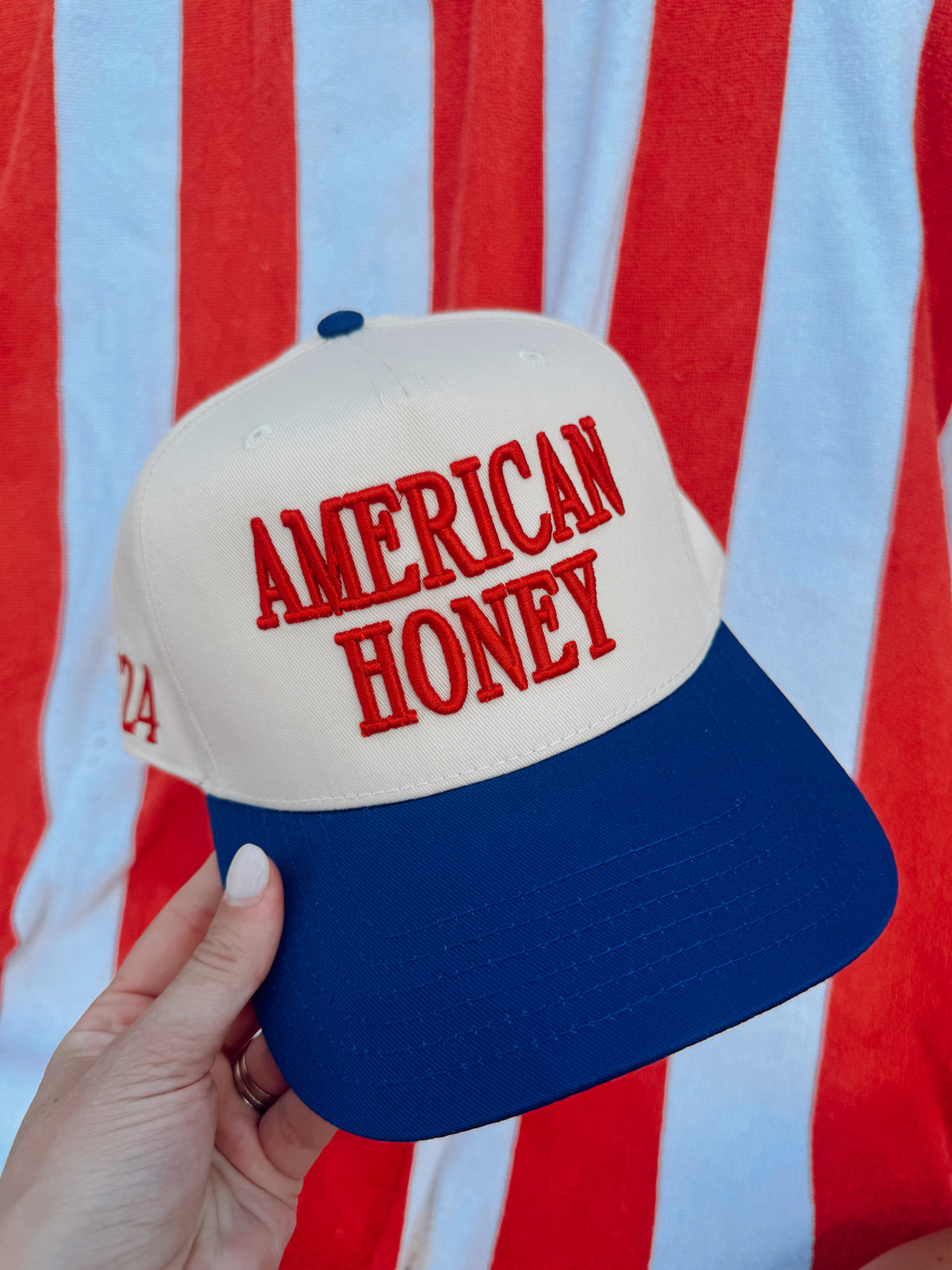 Vintage trucker cap, white and blue, red “AMERICAN HONEY” lettering on front panel.