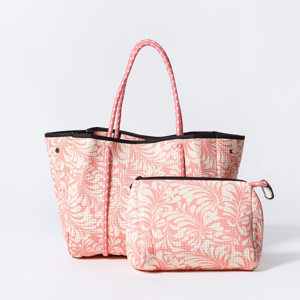 Pink palm-leaf tote bag with black handles and matching zip pouch
