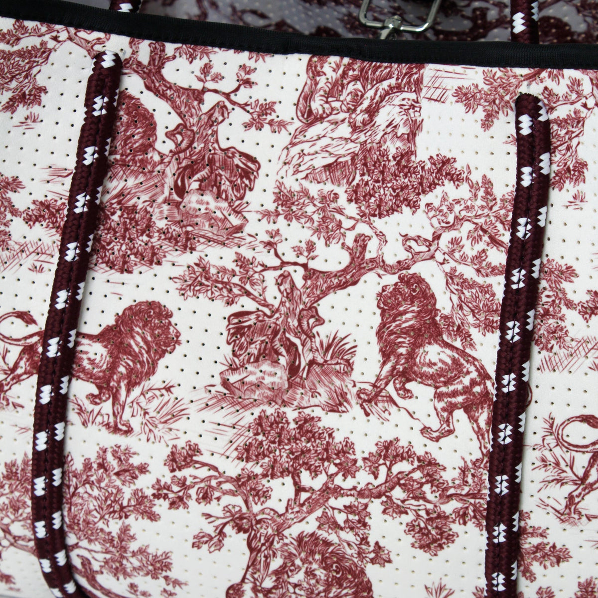 Close-up of red-and-white toile print lining with black piping and stitched edges
