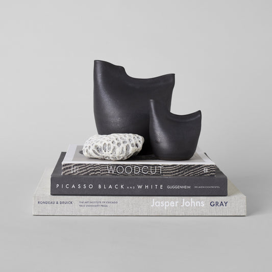 Matte black bird vase trio with staggered sizes and smooth curved lip openings.