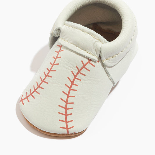 White baby baseball shoe with red laced-stitch design and padded ankle opening