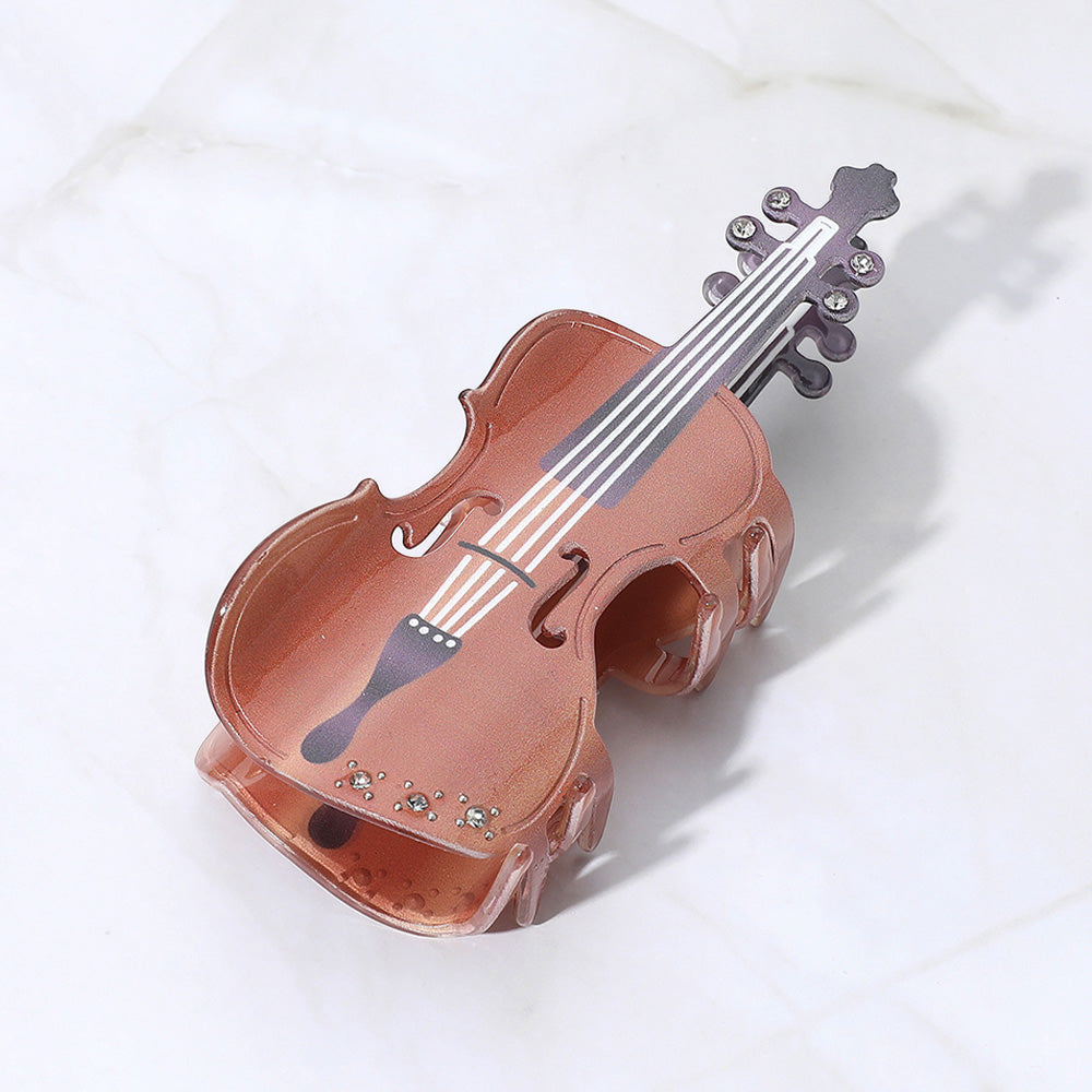Violin-shaped hair claw clip in brown with shiny detail and metal prongs