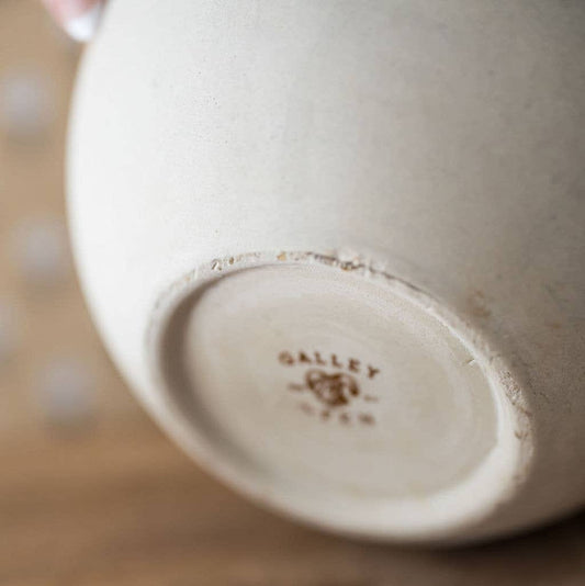 Stoneware bowl base with embossed mark and worn glaze edges