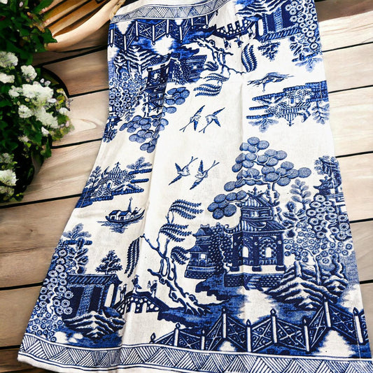 Chinoiserie tea towel with blue-and-white landscape pattern and fringed edge