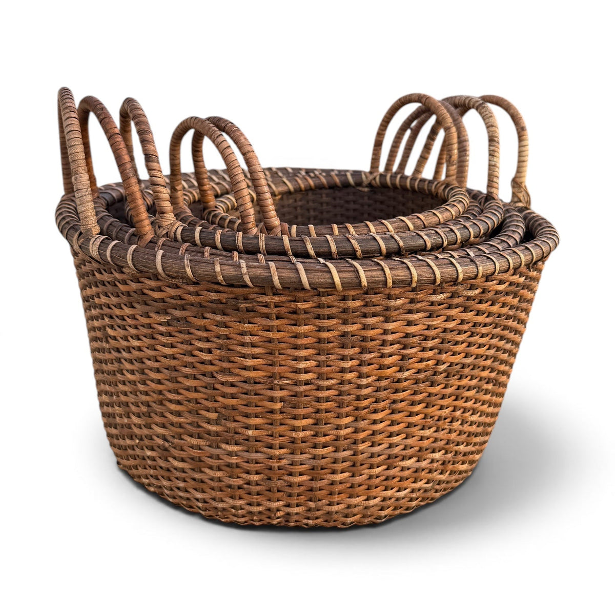 Nested set of woven rattan produce baskets with loop handles in different sizes