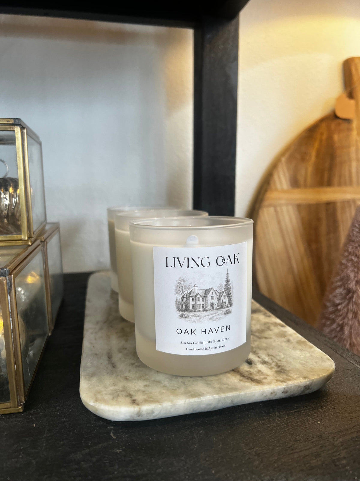 White candle with 'Living Oak' 'Oak Haven' label, unlit wick