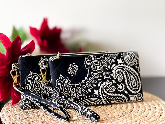 Quilted wristlet pouch with paisley print, gold chain wrist strap, and zip closure
