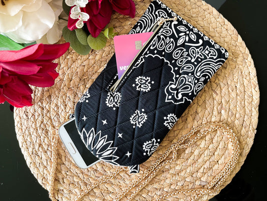 Black crossbody phone sling with white paisley bandana print and gold chain strap
