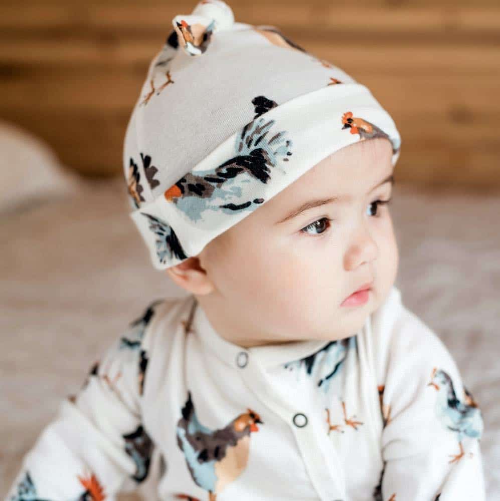 Toddler wearing tulip-print knotted beanie hat with folded top knot