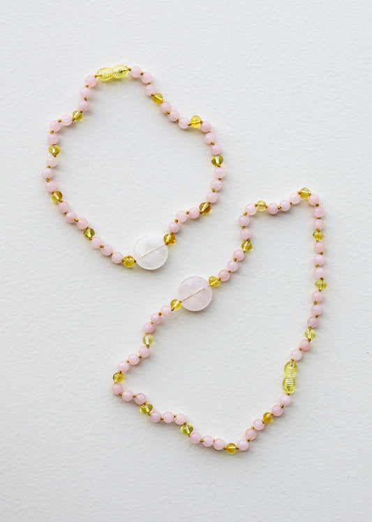 Stone bead necklace set with pink beads and gold oval charms, rose quartz pendant