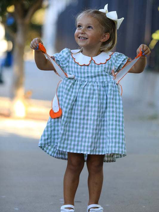 Girls green gingham dress with orange pumpkin tassel ties and white Peter Pan collar