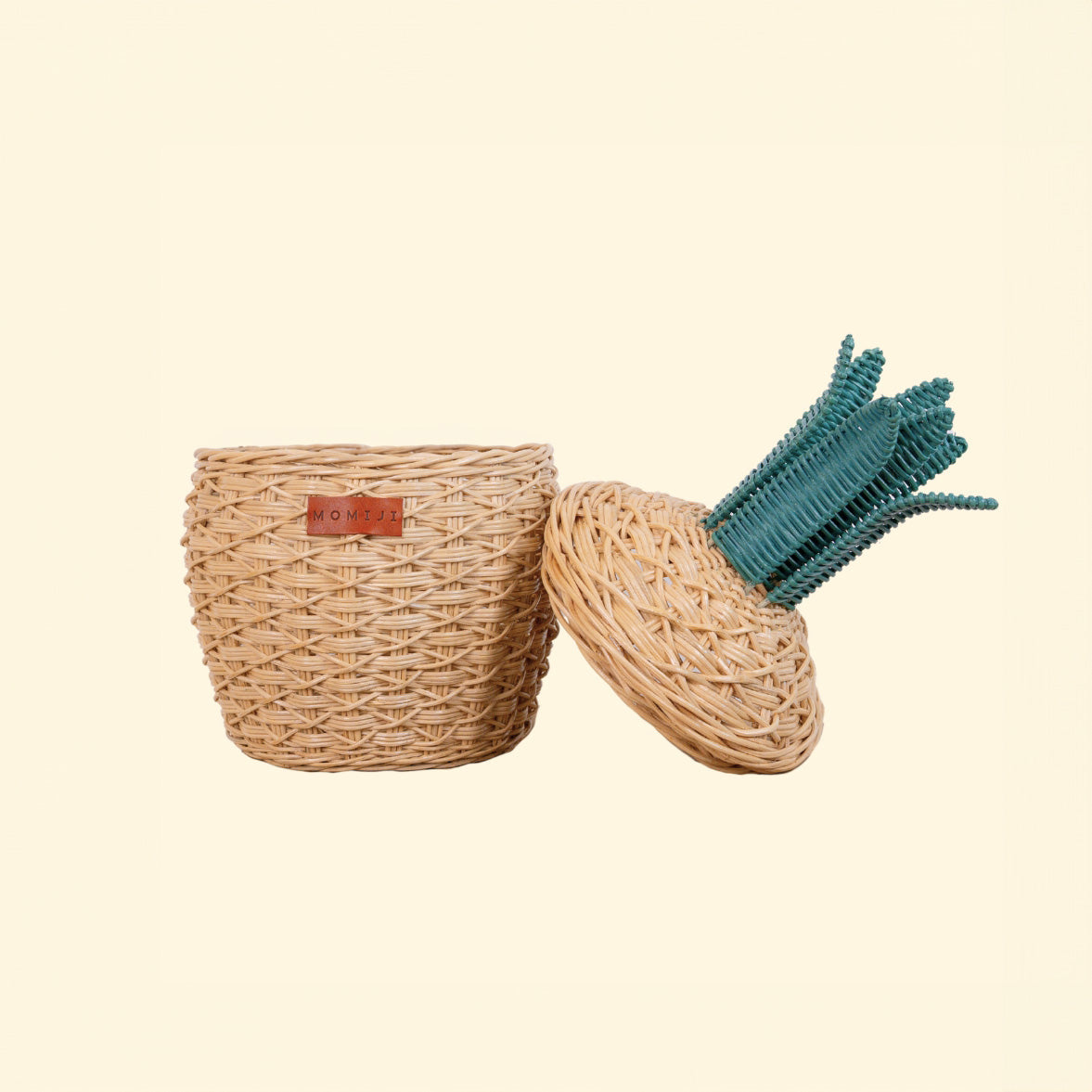 Natural rattan pineapple basket shown open beside its leafy lid