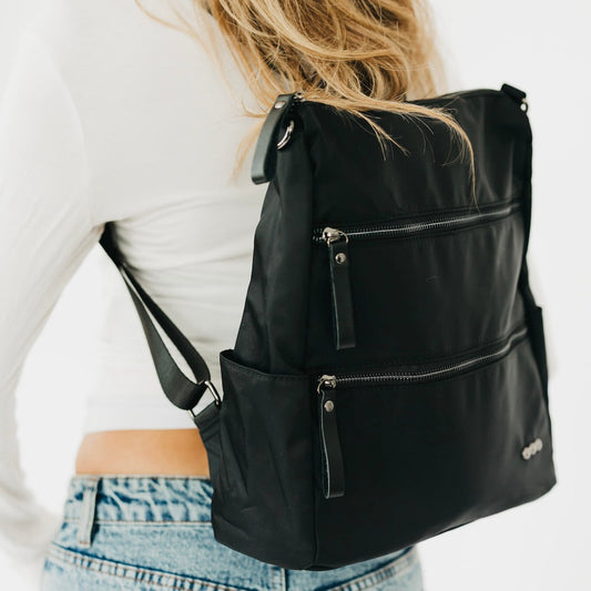 Nylon backpack purse in black, front view with two zippered compartments and strap