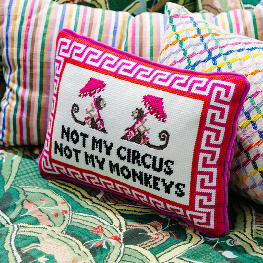 Embroidered needlepoint throw pillow with Greek key edge and "Not my circus" monkeys text