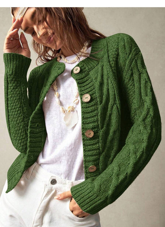 Green twist-knit cropped cardigan with round neck and wooden button front, cable sleeves.