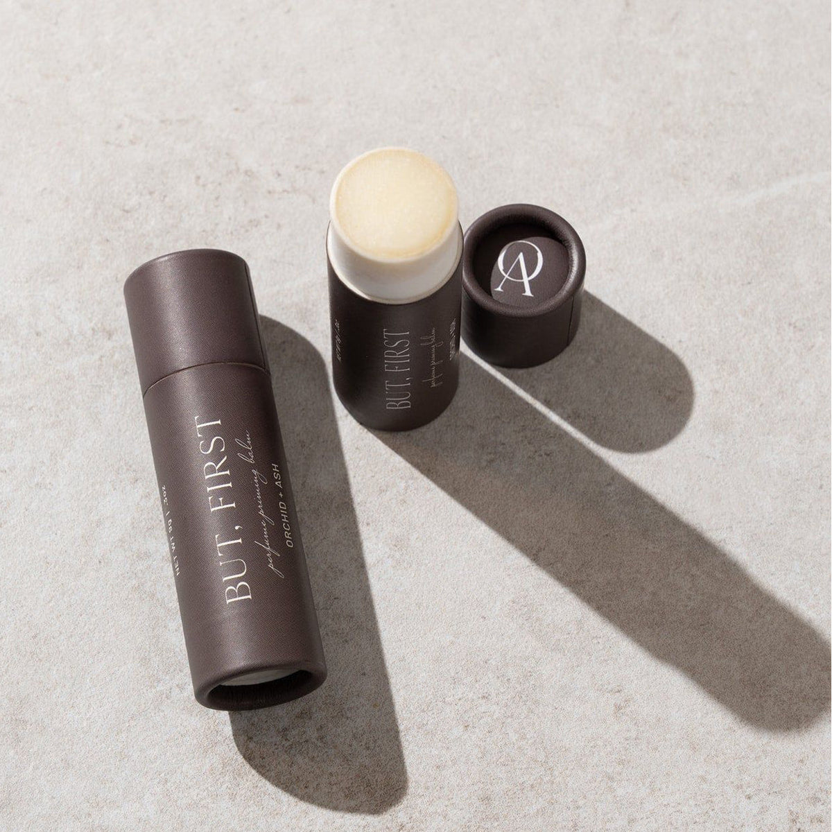 BUT, FIRST perfume priming balm tubes with open lid and round balm disk