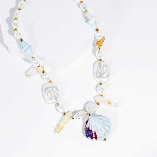 Beaded ocean necklace with gold spacers and blue fan shell plus clear shell charms