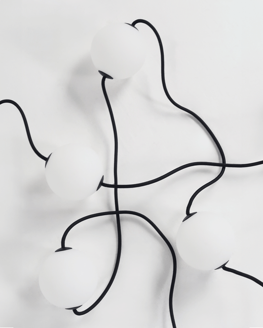 Orb string lights with matte white spheres connected by black cords