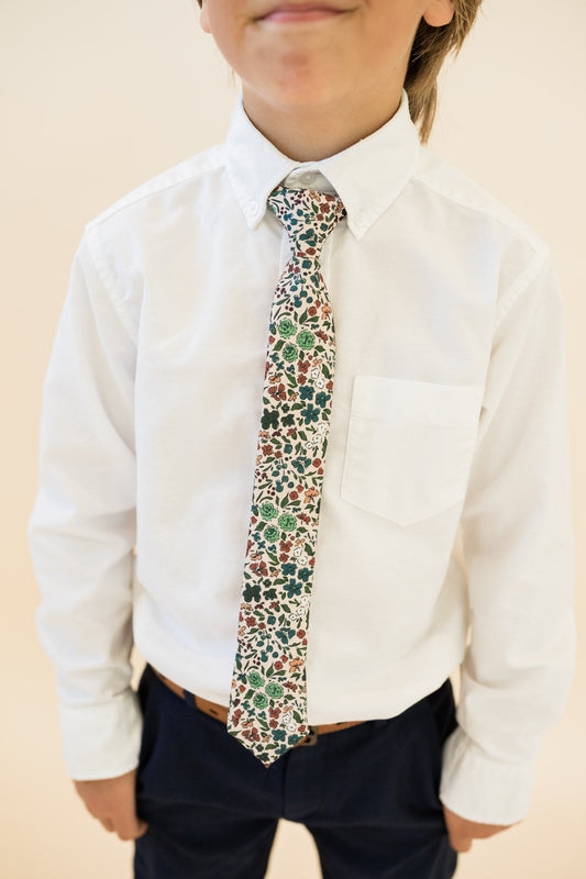 Boys floral tie worn with white button-down shirt and dark trousers